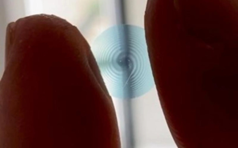 Образец спиральной контактной линзы, зажатый между пальцами исследователя.
