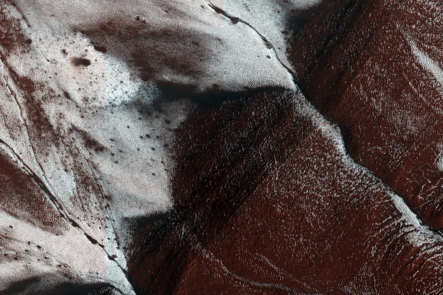 Это поверхность Марса, размером приблизительно 1,5 на 3 километра, показывает овраги на южном склоне в кратере запыленном замороженным углекислым газом. Фото было снято камерой HiRISE на орбитальном аппарате Mars Reconaissance Orbiter.