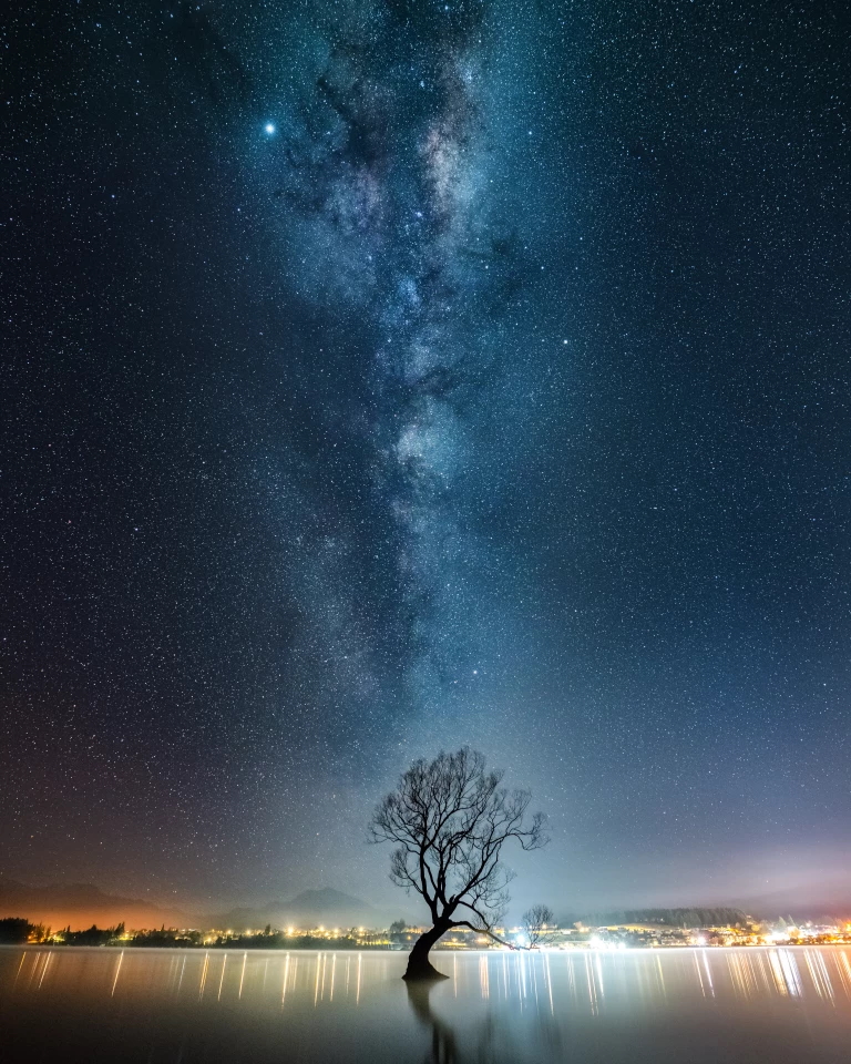 Финалист в категории Астро-фото: "Млечный Путь над деревом на озере Уанака в Новой Зеландии". "Когда я прибыл в это место около полуночи, я был единственным там. Это было довольно контрастно по сравнению с обычным потоком фотографов в течение дня. Я собрал вместе 15 изображений, каждое из которых было выдержкой в 4 секунды". Фото: Douglas Thorne