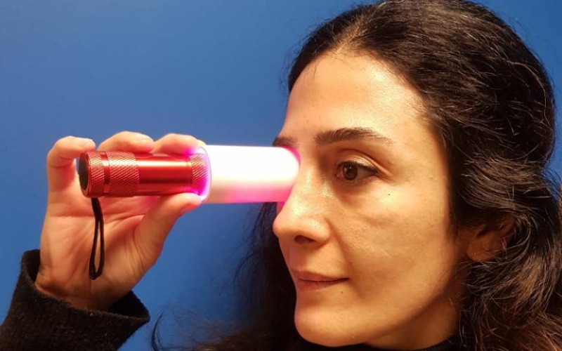 Доктор Пардис Кайнежад (Институт офтальмологии Университетского колледжа Лондона) освещает ее глаз темно-красным светом, который помогает стимулировать митохондрии в ее клетках сетчатки.