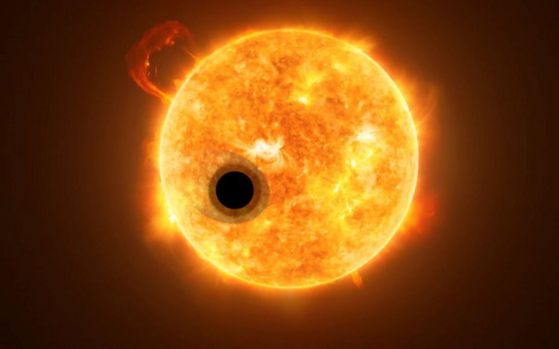 Художник представил экзопланету WASP-107b в силуэте на фоне звезды, раскрывая различные слои ее атмосферы.