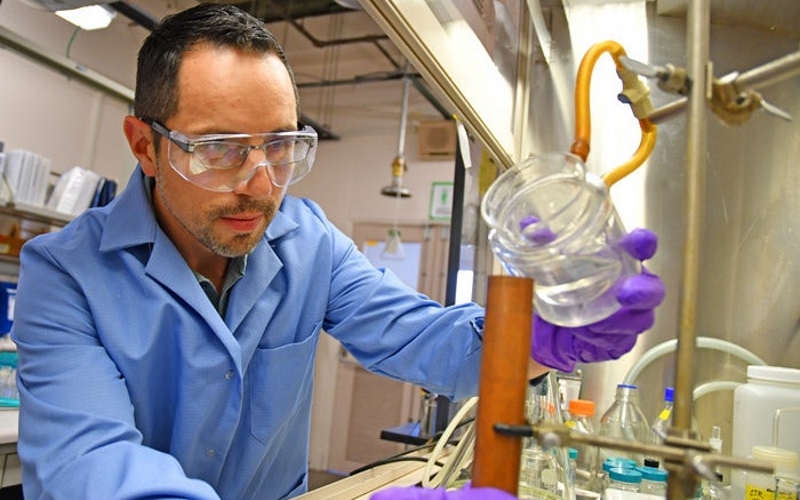 Химик по взрывчатке Дэвид Чавес вливает образец расплавленной литьевой взрывчатки в медную пресс-форму в Лос-Аламосской национальной лаборатории.