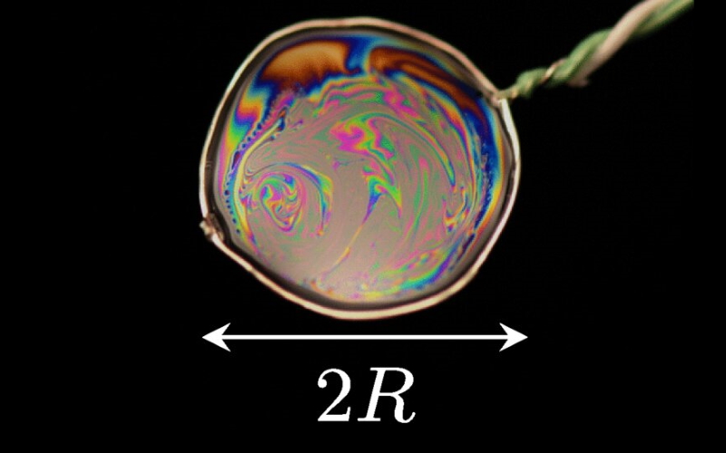 Фотография мыльной пленки, висящей на раме, состоящей из зонда термопары. Радиус мыльной пленки на этом снимке R = 6 мм.