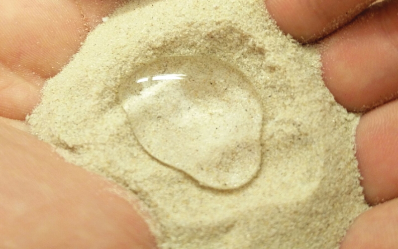 Образец супергидрофобного песка, покрытого очищенным парафиновым воском.