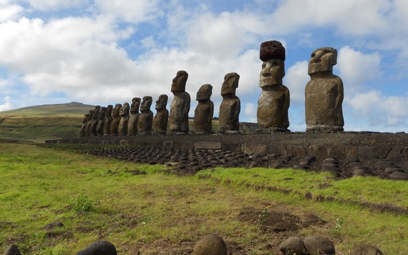 Ряд статуй Моаи на острове Пасхи, на вторую справа одета красная каменная шляпа, пукао.